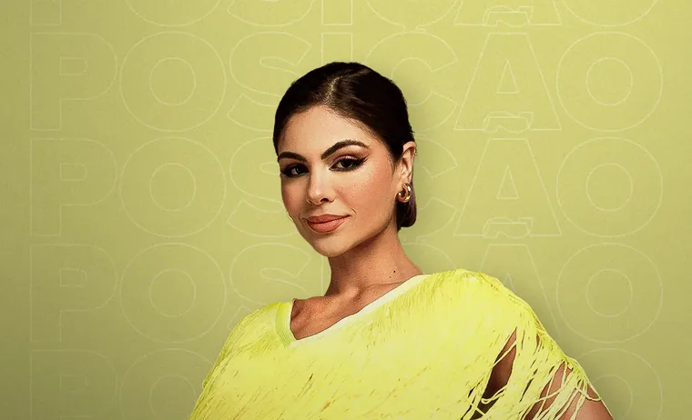 Catarina Leal de vestido amarelo de franjas, com a mão na cintura