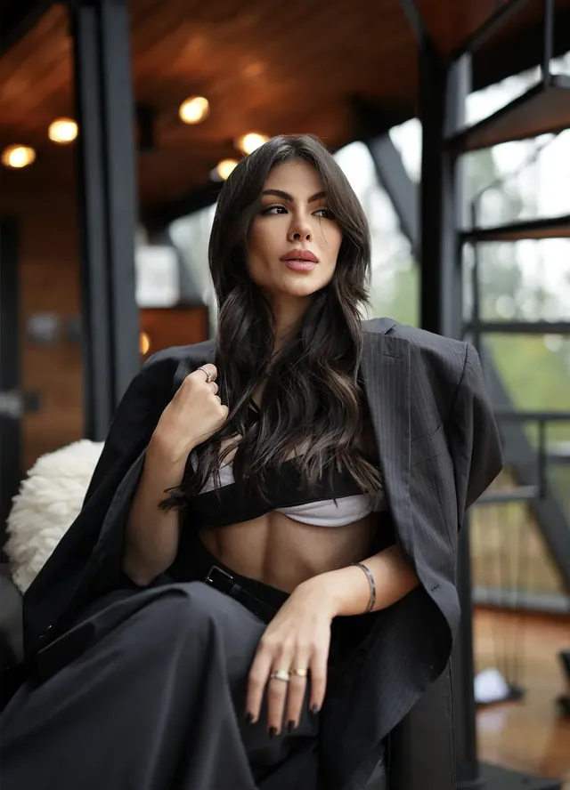 Passo 4: a Catarina sentada, de blazer escuro, fazendo a pose escolhida