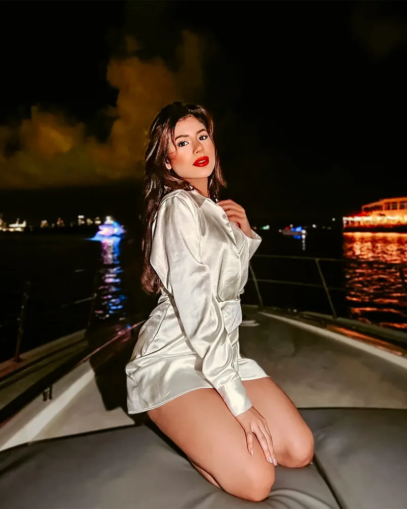Depois do preset: mulher de vestido branco num barco, à noite, com luzes quentes