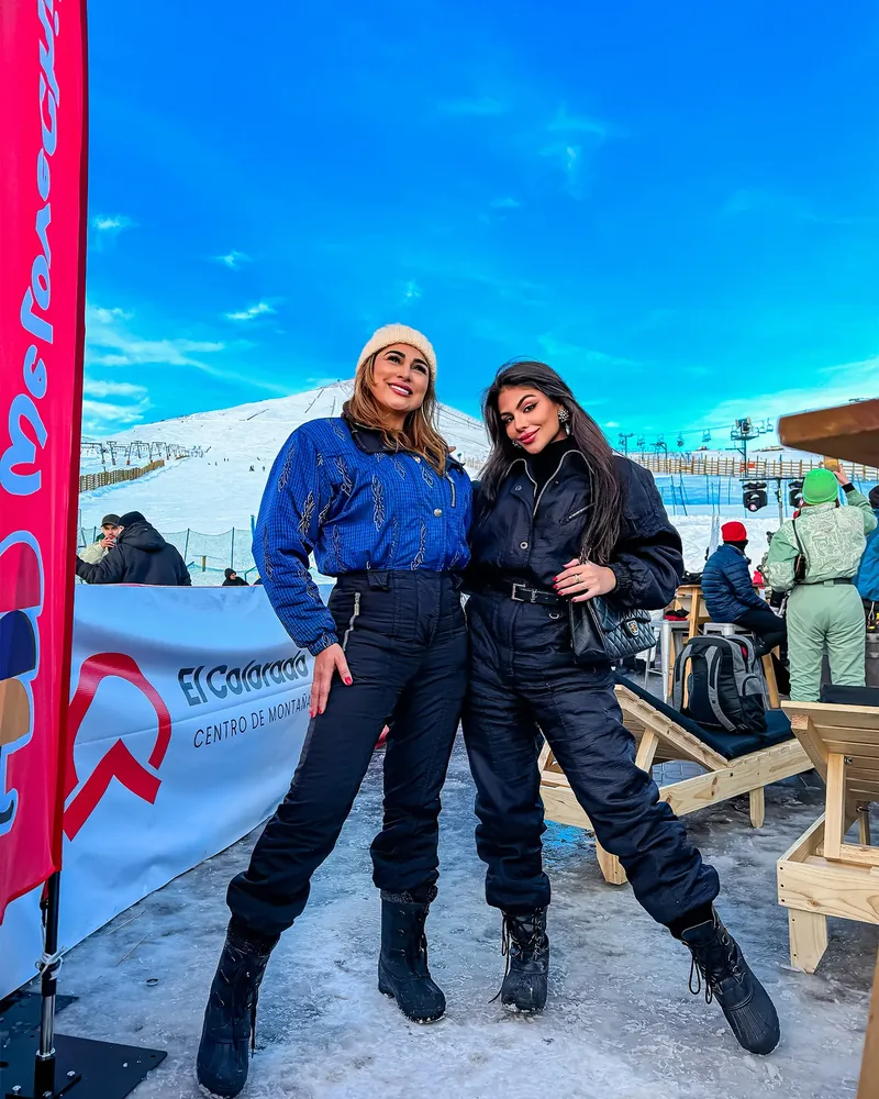 Depois do preset: duas amigas com roupa de neve numa estação de esqui, céu azul