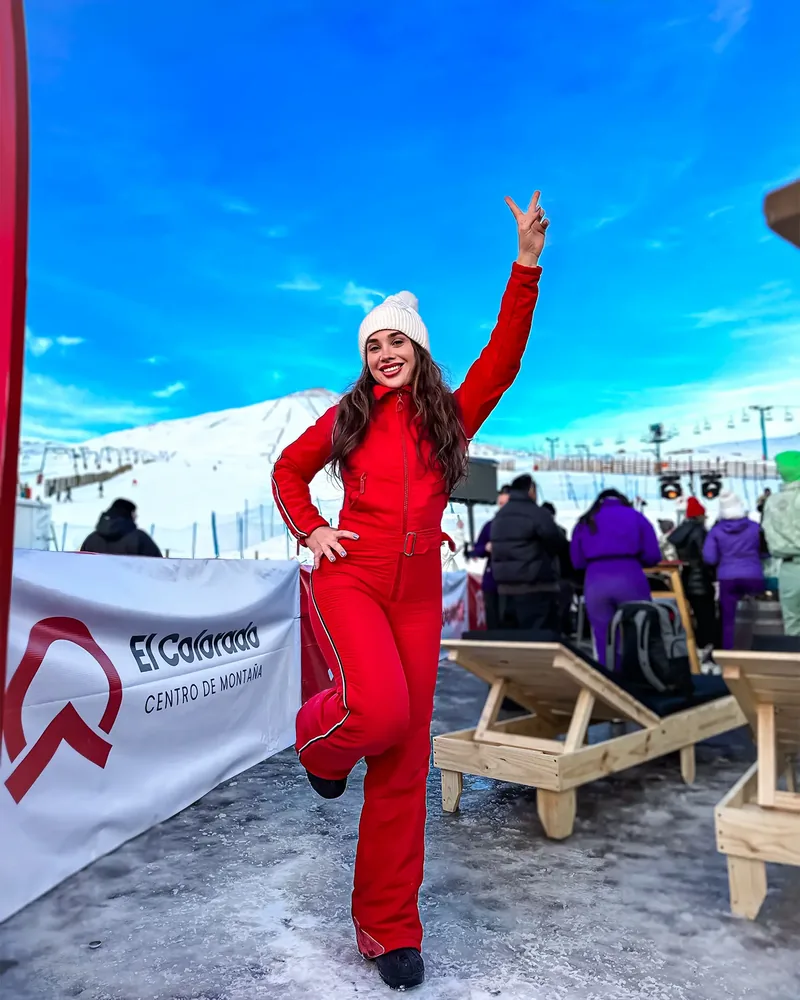 Depois do preset: Catarina de macacão vermelho na neve, de braço erguido
