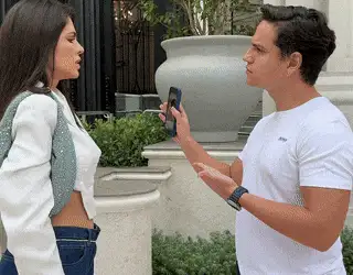 Catarina discutindo com um rapaz que segura o celular para fotografá-la